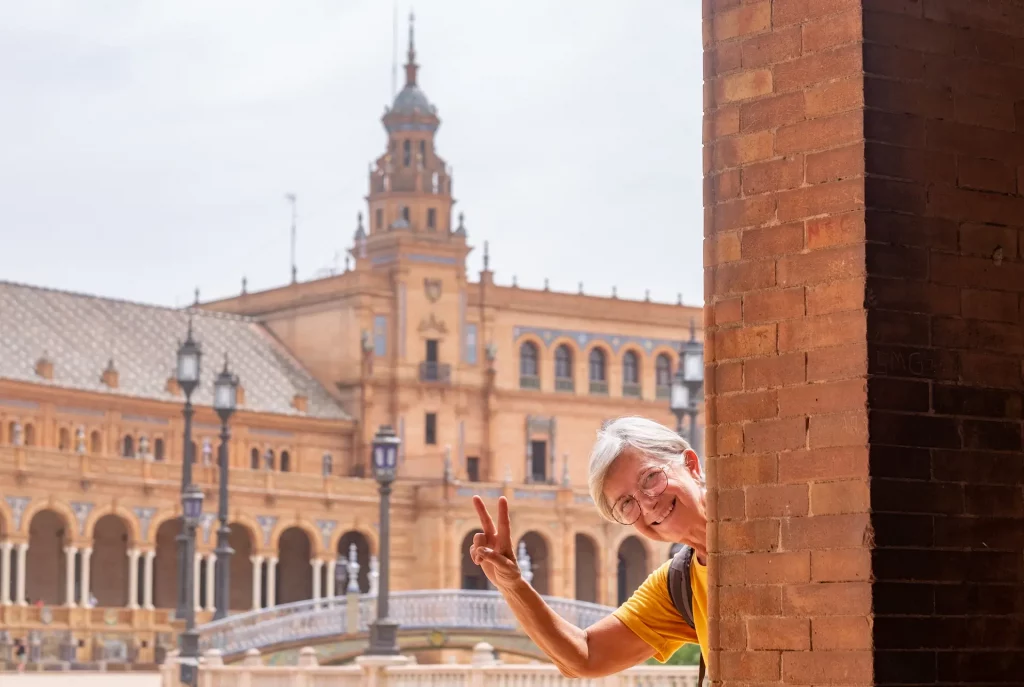 Viajes para todas las edades: turista disfrutando de una visita guiada por la monumental Plaza de España en Sevilla.