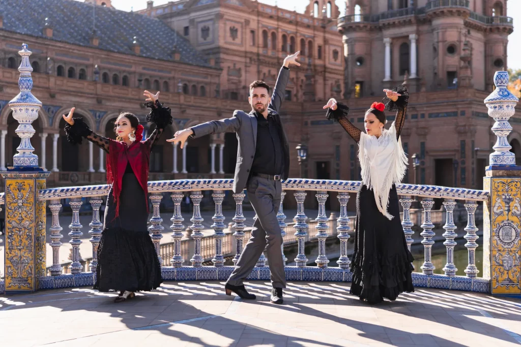Espectáculo de flamenco en Sevilla: artistas bailando con trajes típicos en la monumental Plaza de España, una experiencia cultural única en Andalucía.