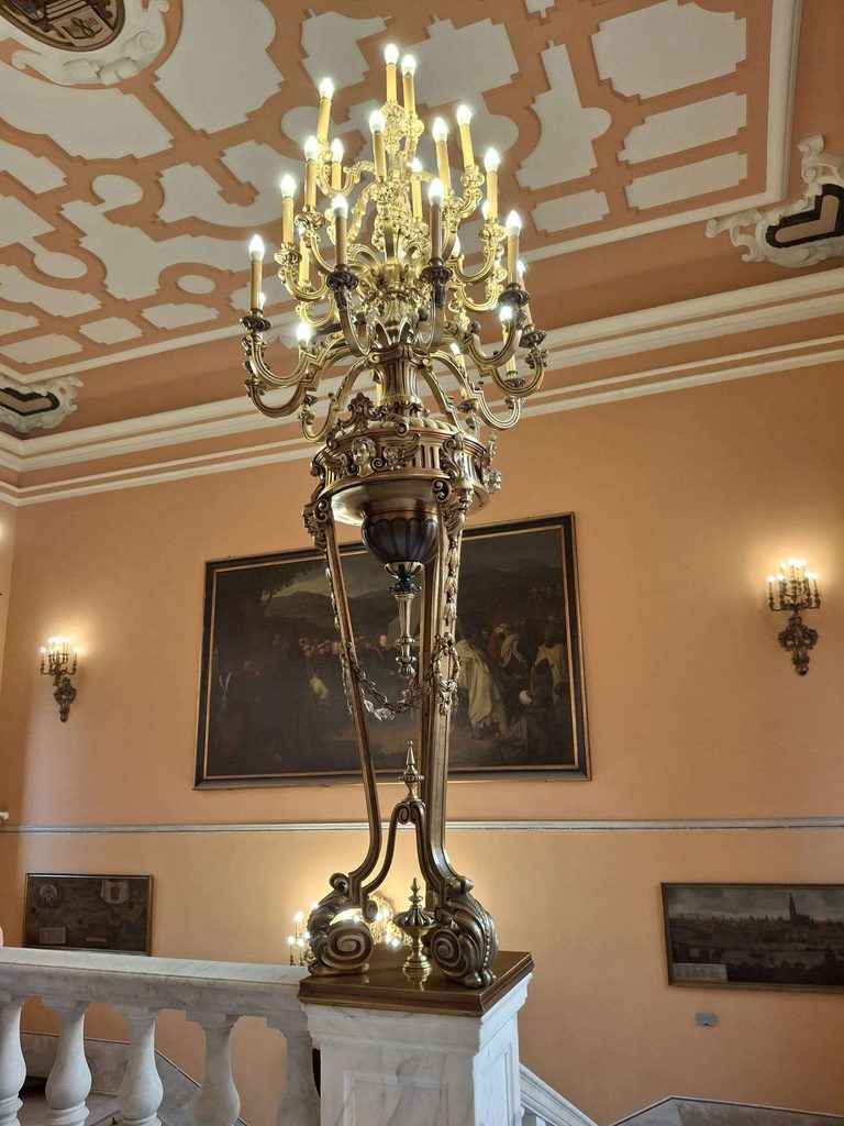 Gran candelabro de bronce dorado sobre la escalera de m&aacute;rmol del ayuntamiento de sevilla